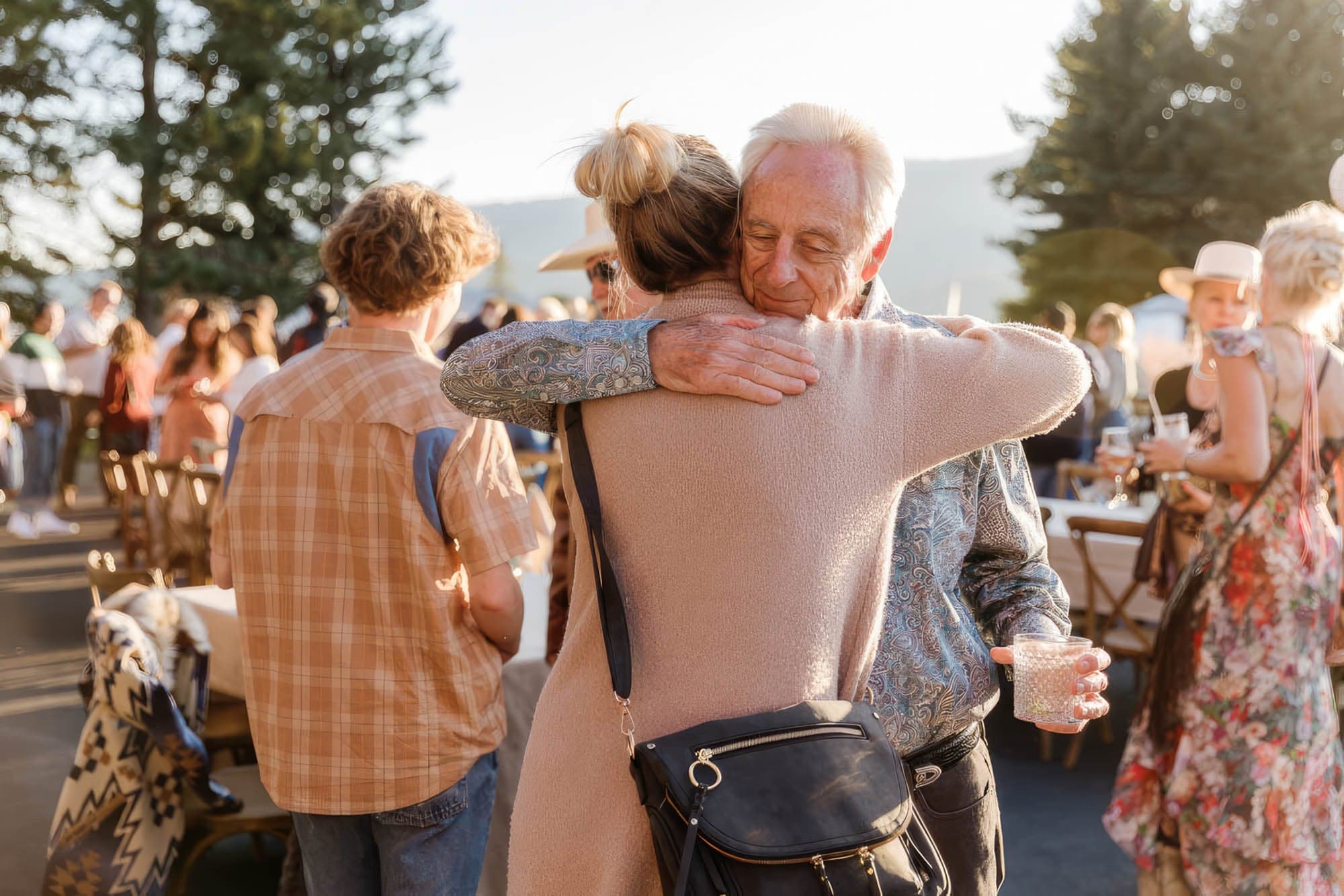 A couple hugging at an outdoor social event