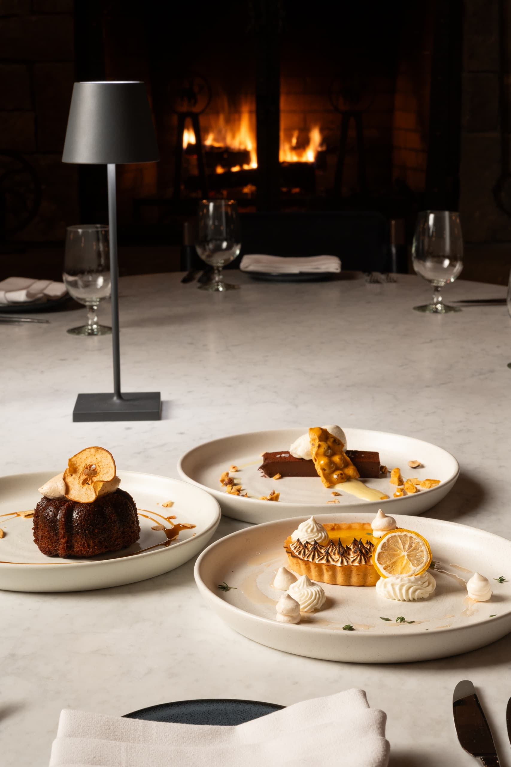 Various desserts on plates by a fire