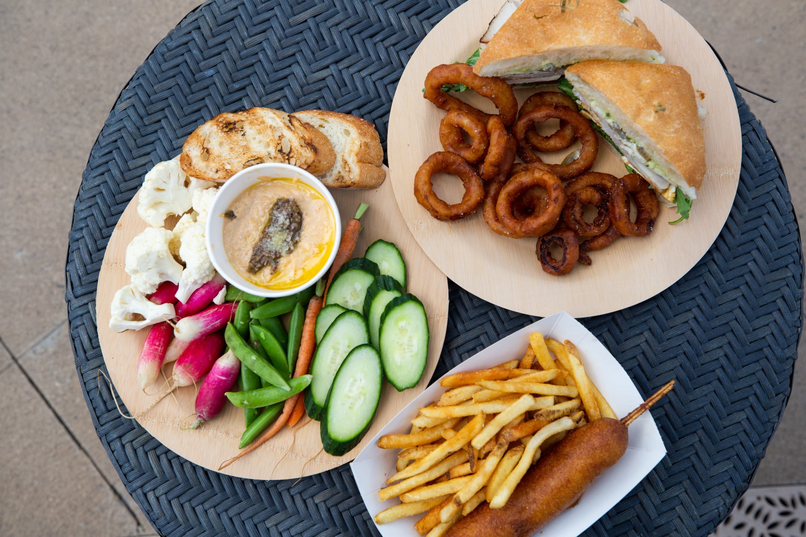 Plates of Martin Creek Poolside Grill food on an outdoor table.