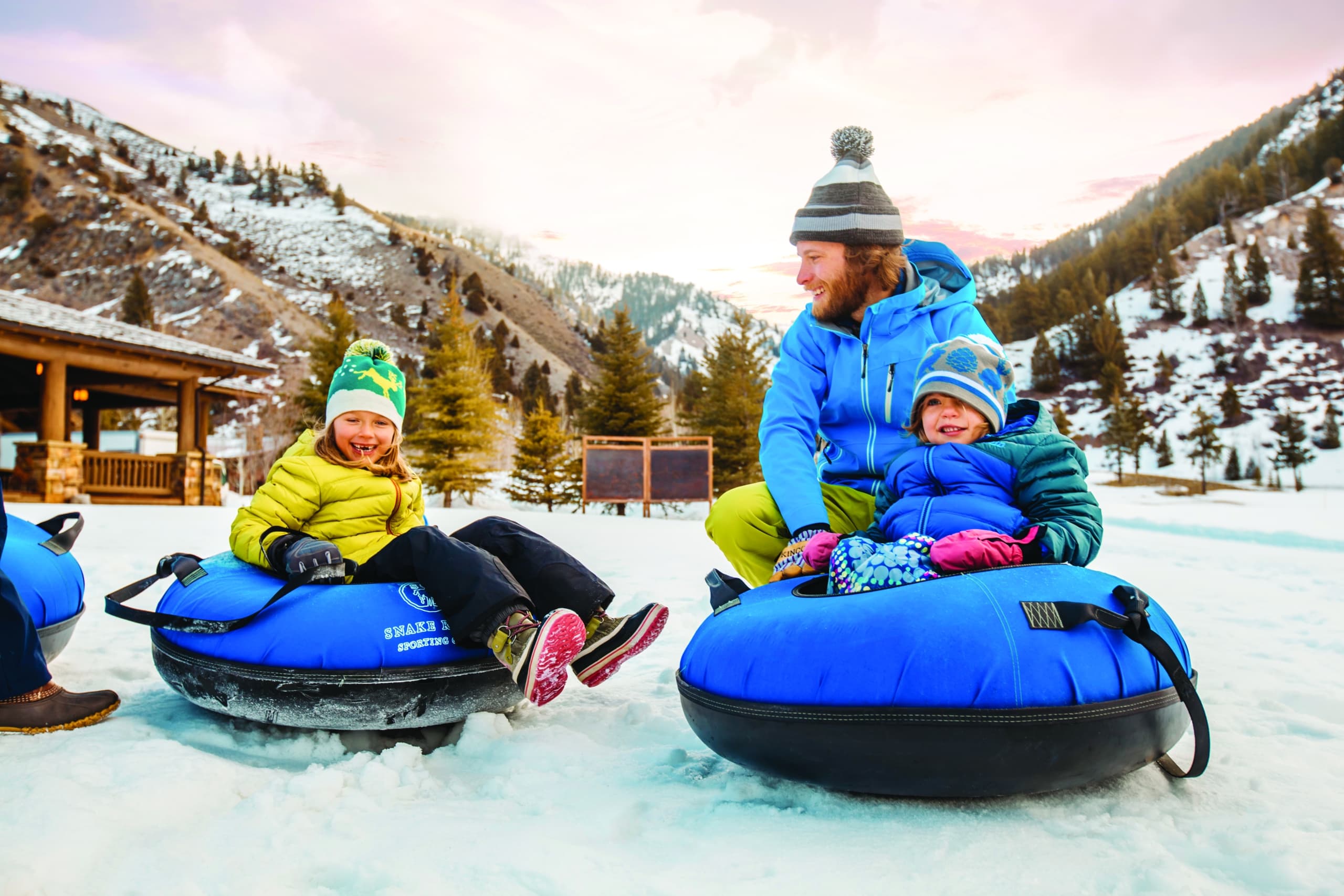 A family with two young children snow tubing in Jackson Hole, WY.