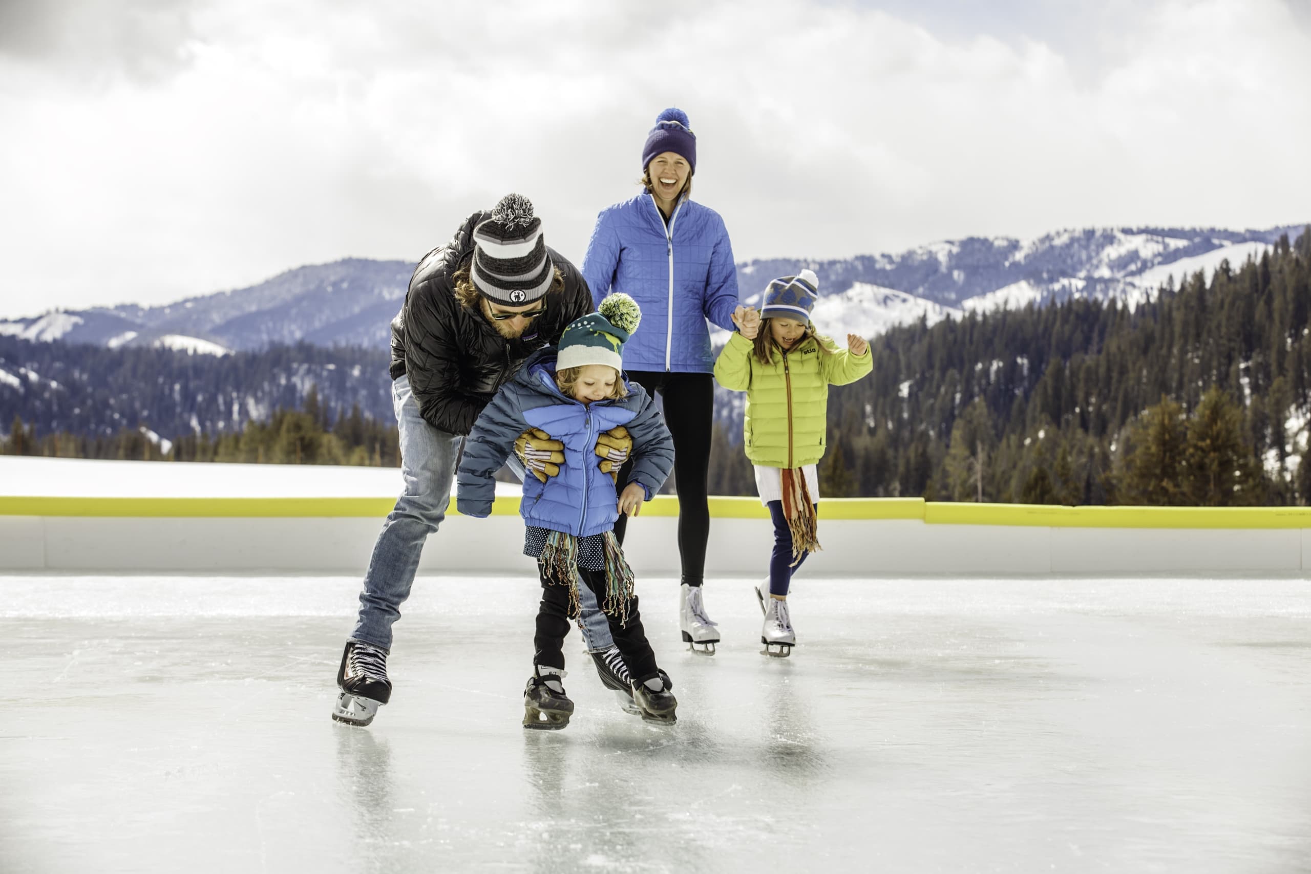 A family with two young children ice skating outdoors at Snake River Sporting Club.