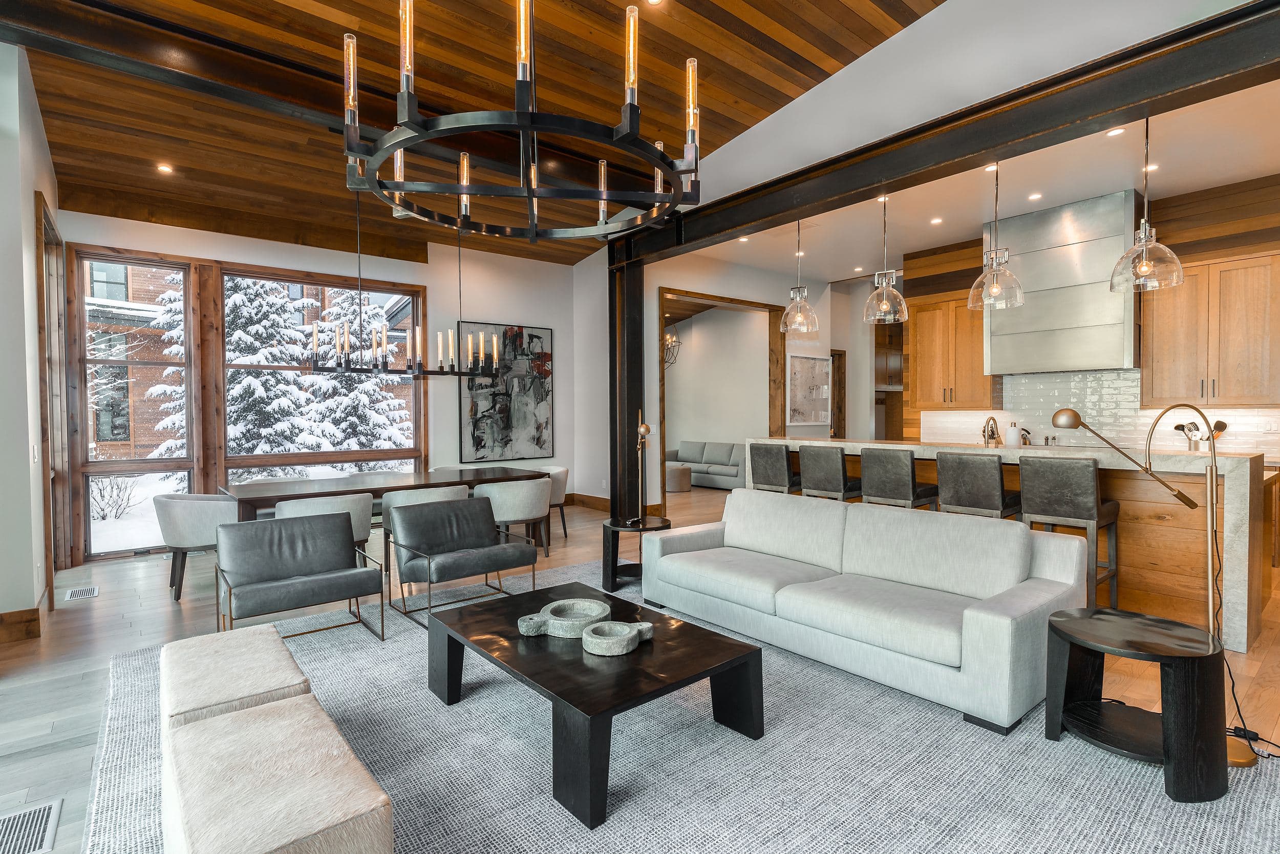 Caddis cabin great room with iron chandelier and winter views at Snake River Sporting Club, Jackson Hole